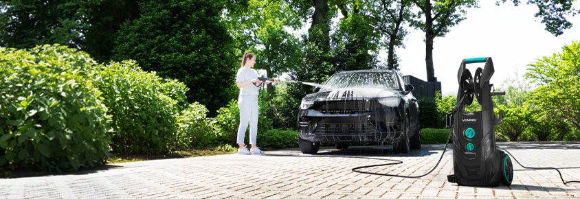 nő tisztítja az autót a VONROC V25 nagynyomású tisztítóval