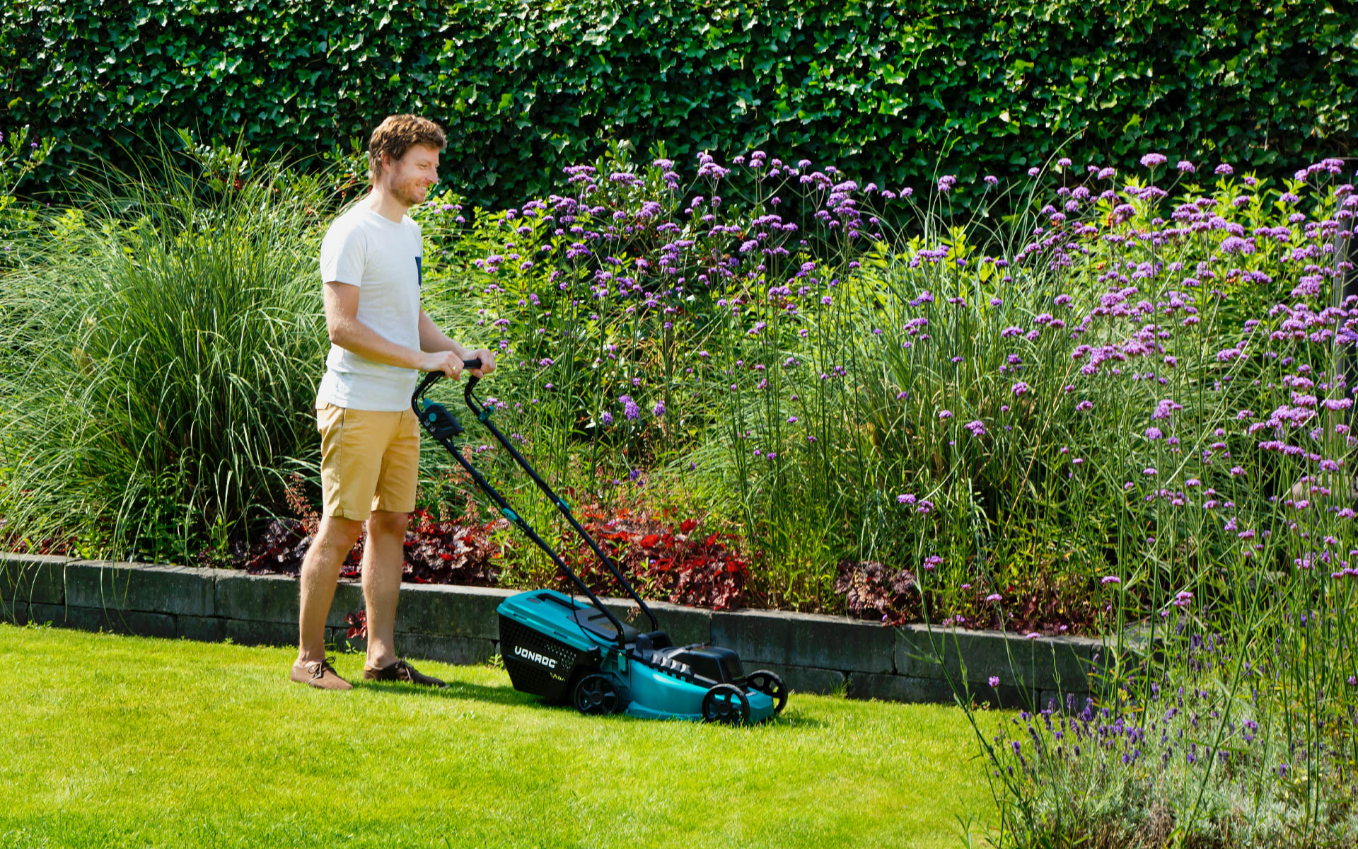 Man mowing his grass with a VONROC Lawnmower